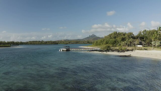 Aerial view of a woman on the beach along the shore with umbrellas at sunset, Ilot Lievres, Trou d'Eau Douce, Flacq district, Mauritius.