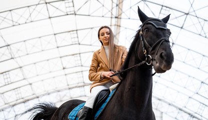 A woman riding on the back of a black horse. A Majestic Woman Riding on the Back of a Powerful...