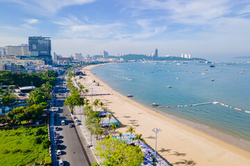 Fototapeta na wymiar Pattaya Thailand, a view of the beach road with hotels palm trees and skyscrapers buildings alongside the renovated new beach road on a sunny day