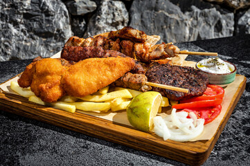 Wooden board showcasing a delectable mix of perfectly grilled meats,  paired with golden French...