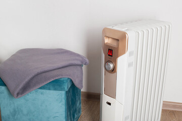 Electric heater on a white background next to a warm blanket. The concept of fire safety during the...