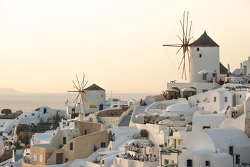 Santorini greek island old town view with white mills and other buildings on sunset. High quality...