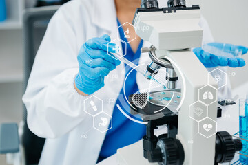 scientists conducting research investigations in a medical laboratory, a researcher in the foreground is using a microscope in laboratory for medicine.  ..
