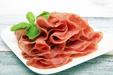 thinly sliced salami, delicious snack rustic salami on table