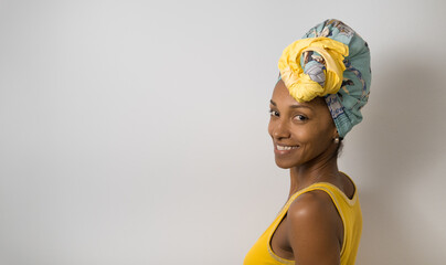 Portrait of beautiful happy young casual black woman wearing a headwrap. - 677633046