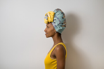 Profile portrait of beautiful happy young casual black woman wearing a headwrap. - 677633055