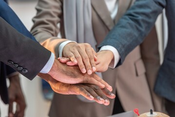 multiethnic business teamwork putting join hands together. Unity and teamwork show by Stack mix of...