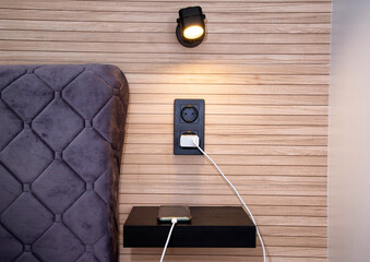 Phone on charge on the bedside shelf in the bedroom.