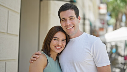 Fototapeta premium Beautiful couple smiling confident hugging each other at street