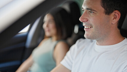 Beautiful couple smiling confident driving car at street