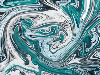 An abstract image of swirling blue, white, and black colors, giving a sense of movement, flow, depth, and texture, resembling a close-up of a fluid or liquid