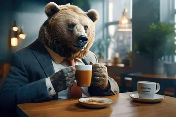 Foto auf Acrylglas A man wearing a bear suit sits at a table, enjoying a cup of coffee. This image can be used to depict a quirky and playful character or to represent someone enjoying a relaxing moment. © Fotograf