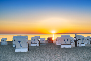 Sunrise on the beach by the Baltic Sea with beach chairs