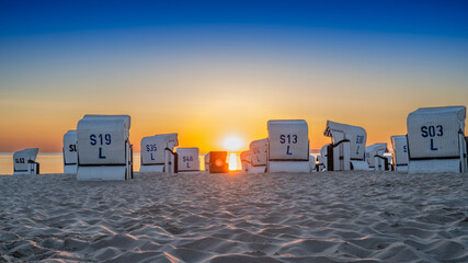 Sunrise on the beach by the Baltic Sea with beach chairs - obrazy, fototapety, plakaty