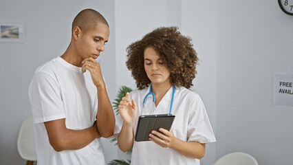 Doctor and patient engrossed in a serious medical consultation at a clinic, working together over a...