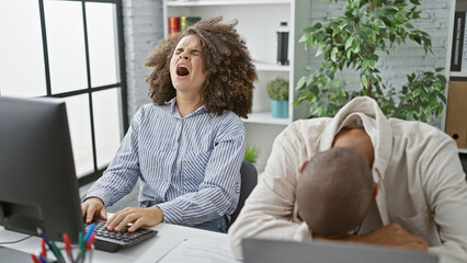 Exhausted man and woman coworkers working tirelessly on computer, two weary office workers fighting the yawn indoors