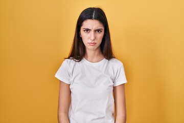 Obraz premium Young beautiful woman standing over yellow background skeptic and nervous, frowning upset because of problem. negative person.