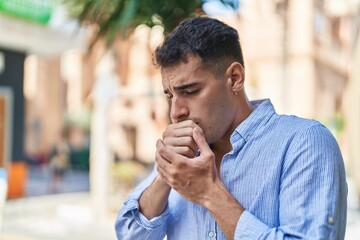 Young hispanic man coughing at street