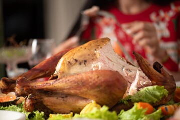 Turkey dinner Thanksgiving food. Man carry Christmas turkey food dinner Serve on table. Baked turkey chicken garnished with family Christmas tree and burning candles . Roasted turkey table setting