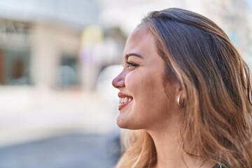 Young beautiful hispanic woman smiling confident looking to the side at street