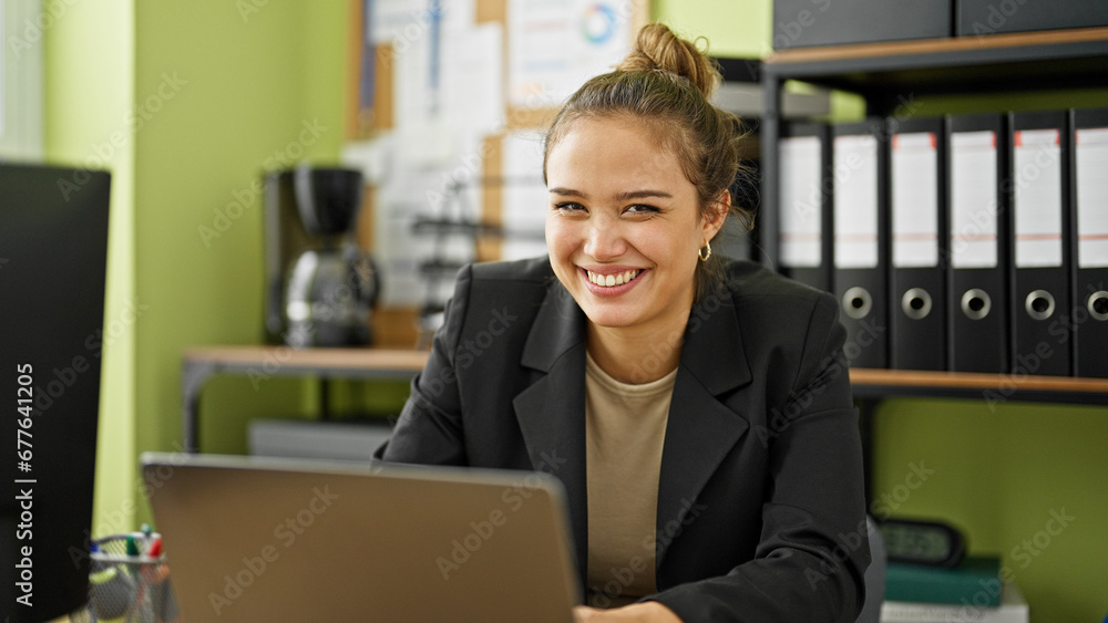 Wall mural Young beautiful hispanic woman business worker using laptop working at office