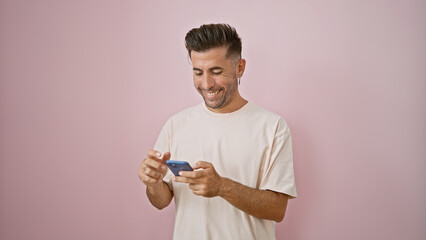 Handsome young hispanic male ecstatically smiling, engrossed in a cheerful online conversation over...