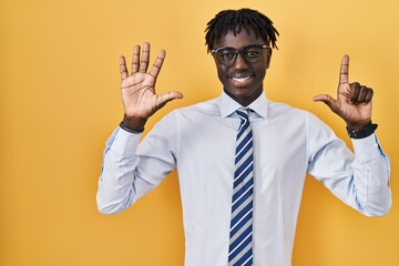 African man with dreadlocks standing over yellow background showing and pointing up with fingers...