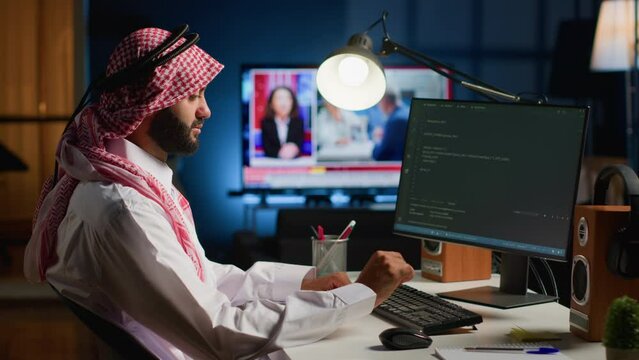 Licensed muslim engineer writing code on computer screen while in office using Java programming languages. Middle Eastern developer working on fixing database errors while working from living room