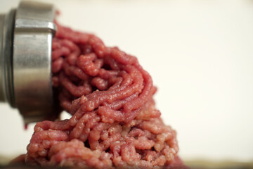 Fresh raw minced meat in the meat grinder, close-up