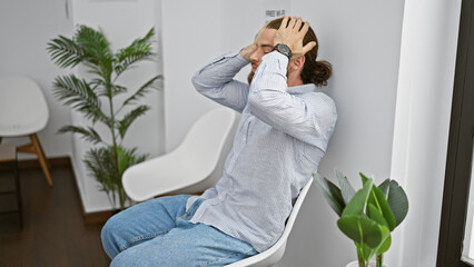 Young hispanic man sitting on chair with serious face stressed at waiting room