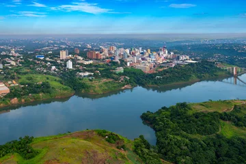 Foto op Canvas Aerial view of the Paraguayan city of Ciudad del Este and Friendship Bridge, connecting Paraguay and Brazil through the border over the Parana River,. © Jose Luis Stephens