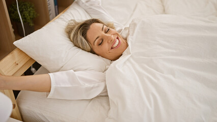 Young blonde woman lying on bed sleeping at bedroom