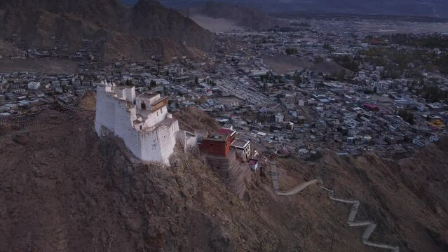 Cinematic drone shot of Sankar Monastery and temple and city of Leh in the background during sunset, Ladakh, India