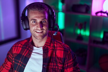 Young caucasian man streamer playing video game using computer at gaming room