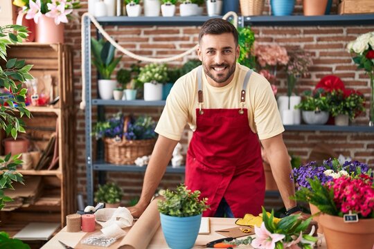Young hispanic man florist smiling confident standing at florist
