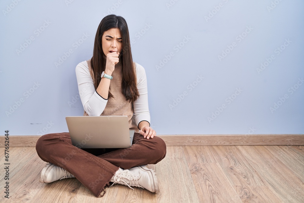 Canvas Prints Young brunette woman working using computer laptop sitting on the floor feeling unwell and coughing as symptom for cold or bronchitis. health care concept.