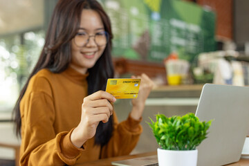 Woman holding credit card and using laptop computer. Online shopping, internet banking