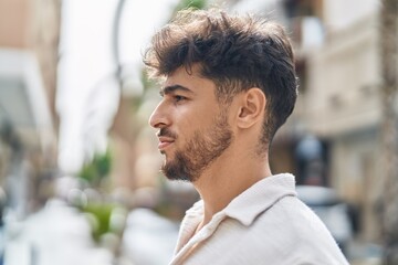 Young arab man looking to the side with relaxed expression at street