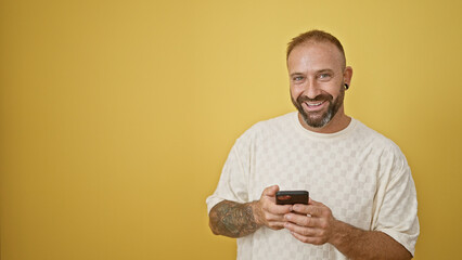 Cheerful young adult man in high spirits, touching his smartphone with a joyful smile, completely...
