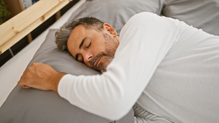 Obraz premium Young hispanic grey-haired man lying on bed sleeping at bedroom