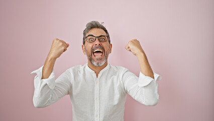 Attractive young hispanic man, grey-haired and wearing glasses, confidently celebrating a win. a...