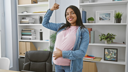 Smiling young pregnant woman, confident business worker, exuding power with a strong gesture,...
