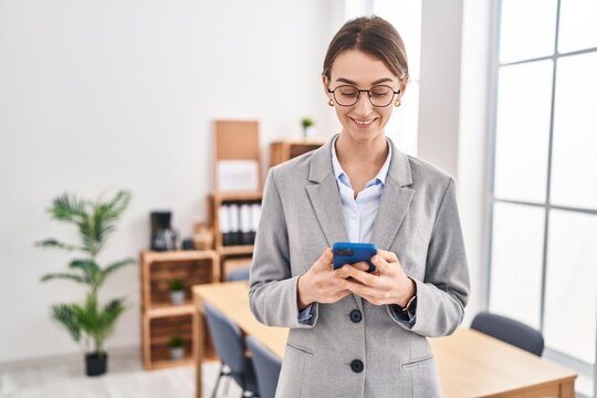 Young caucasian woman business worker smiling confident using smartphone at office