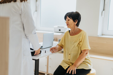 Obraz premium An experienced doctor advises and explains test results to a woman patient in a clinic office.