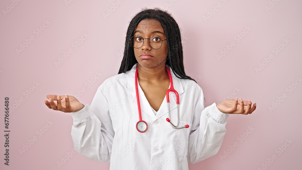 Poster African american woman doctor standing clueless over isolated pink background