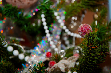 Christmas tree decoration. Decoration for New Year holiday celebration. Happy New Year. Christmas Tree Background. Beautiful Christmas gift near fir tree in room. Festive Christmas scene