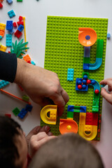 father playing with son lego - obrazy, fototapety, plakaty