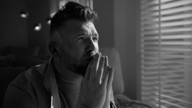 Black and white shot Handsome male sits alone at home troubled negative thoughts slowmo. Pensive deep in sad thoughts man looking window. Sad thoughtful mature 40s man portrait thinking of problems
