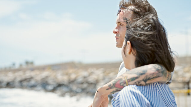 Beautiful Couple Hugging Each Other Standing With Serious Face At Seaside