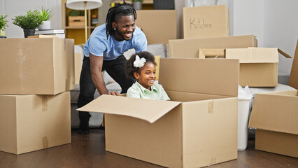 African american father and daughter playing with cardboard box as a car at new home - obrazy, fototapety, plakaty